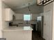 Bright kitchen featuring white cabinets, stainless steel appliances, and a stylish subway tile backsplash at 135 Green Commons Dr, Covington, GA 30016
