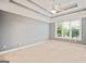 Carpeted main bedroom boasts tray ceiling, large window and neutral wall color at 1979 Spivey Village Dr, Jonesboro, GA 30236