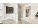 Bright bathroom with a separate tub and shower, neutral tile, and modern fixtures at 11893 Aukerman Way, Hampton, GA 30228
