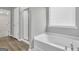 Bathroom featuring a bathtub with a window, a glass shower, and vinyl flooring at 2060 Lanier Harbor Pt, Buford, GA 30518
