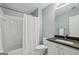 Bathroom with a shower-tub combo, white tile surround, and a vanity with a dark countertop at 770 Spalding Heights Dr, Atlanta, GA 30350