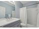 Bathroom featuring a shower-tub combo, vanity with a white countertop and blue-painted walls at 770 Spalding Heights Dr, Atlanta, GA 30350