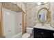 Bathroom features shower-tub combo with attractive black and cream patterned wallpaper at 770 Spalding Heights Dr, Atlanta, GA 30350