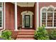 Inviting front porch with brick steps, columns, and decorative glass front door at 770 Spalding Heights Dr, Atlanta, GA 30350
