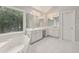 Bright main bathroom features large mirrors, double sink vanity, and jacuzzi tub at 770 Spalding Heights Dr, Atlanta, GA 30350