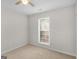 Cozy bedroom with neutral carpet, a ceiling fan, and bright natural light from the window at 404 Northwind Pl, Stockbridge, GA 30281