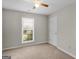 Neutral bedroom features a ceiling fan, plush carpeting, and window letting in natural light at 404 Northwind Pl, Stockbridge, GA 30281