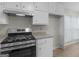 Kitchen featuring white cabinets, granite countertops, and a stainless steel gas range at 404 Northwind Pl, Stockbridge, GA 30281