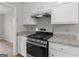 Kitchen featuring white cabinets, granite countertops, and a stainless steel gas range at 404 Northwind Pl, Stockbridge, GA 30281