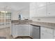 Well-lit kitchen featuring white cabinets, granite countertops, and stainless steel dishwasher at 404 Northwind Pl, Stockbridge, GA 30281