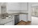 Well-lit kitchen featuring white cabinets, granite countertops, and stainless steel dishwasher at 404 Northwind Pl, Stockbridge, GA 30281