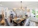 Well-appointed dining room featuring a dark wood table, plush chairs, modern lighting, and beautiful hardwood floors at 4105 Vista Pointe Dr, Cumming, GA 30028