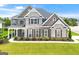Beautiful brick and stone two-story home featuring a lush front lawn and meticulously landscaped flower beds at 4105 Vista Pointe Dr, Cumming, GA 30028
