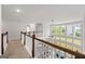 Second floor hallway with wooden railing and large windows with natural light at 4105 Vista Pointe Dr, Cumming, GA 30028