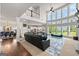 Spacious living area with tall windows, hardwood floors, fireplace, and an open layout to the dining area at 4105 Vista Pointe Dr, Cumming, GA 30028