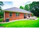 View of brick house with lots of windows, patio seating, and a green lawn at 109 National Way, Carrollton, GA 30116