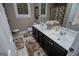 Bathroom featuring double sinks, tile floors and dark wood cabinets at 109 National Way, Carrollton, GA 30116