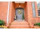 Welcoming front entrance adorned with brick steps and an elegant wreath, enhanced by lush landscaping at 109 National Way, Carrollton, GA 30116