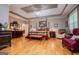 Bright main bedroom with hardwood floors, a tray ceiling, and a seating area at 109 National Way, Carrollton, GA 30116