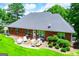 Beautiful brick home featuring a patio and outdoor seating area surrounded by a well-maintained lawn and lush landscaping at 109 National Way, Carrollton, GA 30116