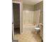 This tiled bathroom has a tub with tile walls, plus a toilet and shelving at 207 Oak N Cir, Stockbridge, GA 30281