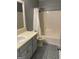 This is a bathroom with gray cabinets, patterned floors, and a shower/tub combo at 207 Oak N Cir, Stockbridge, GA 30281