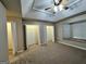 A carpeted bedroom with a ceiling fan, a tray ceiling, two large closets, and a window seat at 207 Oak N Cir, Stockbridge, GA 30281
