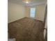 A well-lit bedroom featuring neutral walls, plush carpeting, and a window with blinds for ample natural light at 2985 Garnet Way, South Fulton, GA 30349