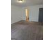 Spacious living room featuring neutral walls, plush carpeting, and easy access to the bathroom at 2985 Garnet Way, South Fulton, GA 30349