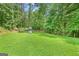 Lush, green backyard with mature trees and a swing set at 107 Meadowbrook Ln, Grantville, GA 30220