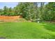 Large backyard features green grass, trees, a wooden fence, and a playset at 107 Meadowbrook Ln, Grantville, GA 30220