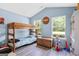 Charming bedroom featuring a bunk bed, light blue walls, and natural light from dual windows at 107 Meadowbrook Ln, Grantville, GA 30220