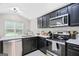 Updated kitchen with black cabinets, stainless steel appliances, and bright countertop space at 107 Meadowbrook Ln, Grantville, GA 30220
