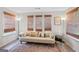 Inviting living room with a comfy couch, accent pillows, bamboo blinds, and wood-look flooring at 107 Meadowbrook Ln, Grantville, GA 30220