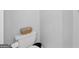 Modern toilet with a decorative basket and white walls at 107 Meadowbrook Ln, Grantville, GA 30220