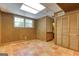 Basement room with terracotta flooring, a closet, a window, and wood-paneled walls at 3700 Tom Brewer Rd, Loganville, GA 30052