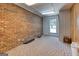 Finished basement room with a window, brick accent wall and carpeted flooring, offering versatile living space at 3700 Tom Brewer Rd, Loganville, GA 30052