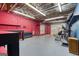 Spacious basement with exposed ceiling, brick wall, workout equipment, and a garage door provides versatile living space at 3700 Tom Brewer Rd, Loganville, GA 30052