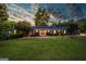 Inviting one-story brick home featuring a lush green lawn and beautifully landscaped yard with mature trees at 3700 Tom Brewer Rd, Loganville, GA 30052