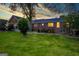 Exterior view of the home's backyard featuring a lush lawn and mature trees, set against a colorful sunset at 3700 Tom Brewer Road, Loganville, GA 30052