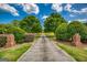 Long paved driveway bordered by manicured greenery, leading to a secluded property under a bright sky at 3700 Tom Brewer Road, Loganville, GA 30052