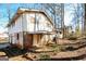 Exterior view of a multi-level home featuring a brick facade, covered patio, mature trees, and a sprawling yard at 2571 Beech St, Morrow, GA 30260