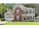 Charming two-story home featuring a brick facade, black shutters, well-manicured lawn, and an attached two-car garage at 139 Ardenlee Dr, Peachtree City, GA 30269