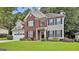 Lovely two-story home boasting a brick and siding exterior, black shutters, and an attached garage, all on a well-maintained lawn at 139 Ardenlee Dr, Peachtree City, GA 30269