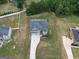 A high aerial view shows the brick and vinyl home, 3 car garage, manicured lawns and mature trees at 293 Ironwood Dr, Stockbridge, GA 30281