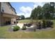 The landscaped backyard features a covered patio with a gas fireplace, grill, and beautiful lawn at 293 Ironwood Dr, Stockbridge, GA 30281