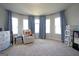 Bright Bedroom with soft blue curtains, neutral carpet, and an accent chair under a curved bay of large windows at 293 Ironwood Dr, Stockbridge, GA 30281