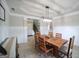 This dining room has a large wooden table, wainscoting, a modern chandelier and a tray ceiling at 293 Ironwood Dr, Stockbridge, GA 30281