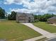 Beautifully landscaped home features a well-maintained lawn and a long driveway leading to a three-car garage at 293 Ironwood Dr, Stockbridge, GA 30281