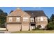 A charming two-story brick home featuring a two-car garage and manicured lawn at 293 Ironwood Dr, Stockbridge, GA 30281